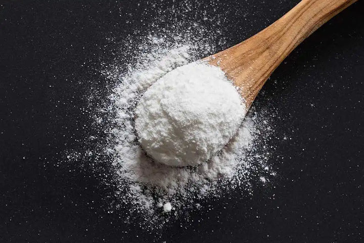 White powder on a wooden spoon.